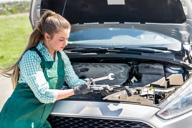 Jonge monteur met verschillende moersleutels en moersleutels voor auto