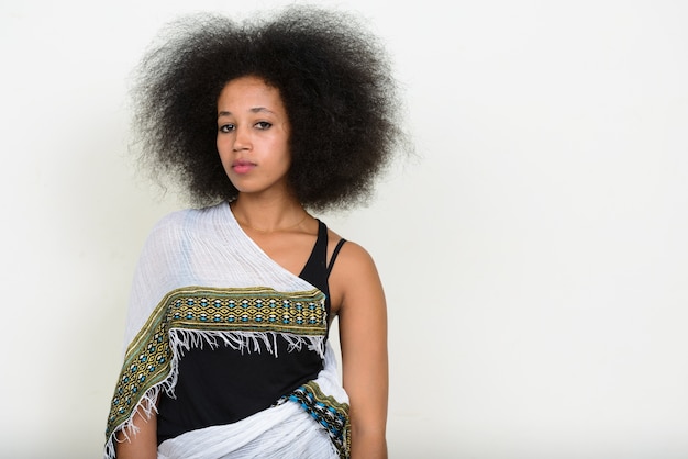 jonge mooie Afrikaanse vrouw met Afro haar in traditionele kleding op wit