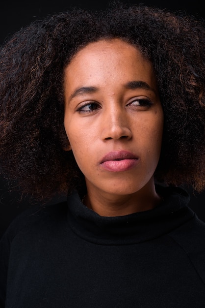 Foto jonge mooie afrikaanse vrouw met afro haar op zwart