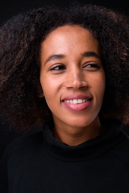 Foto jonge mooie afrikaanse vrouw met afro haar op zwart