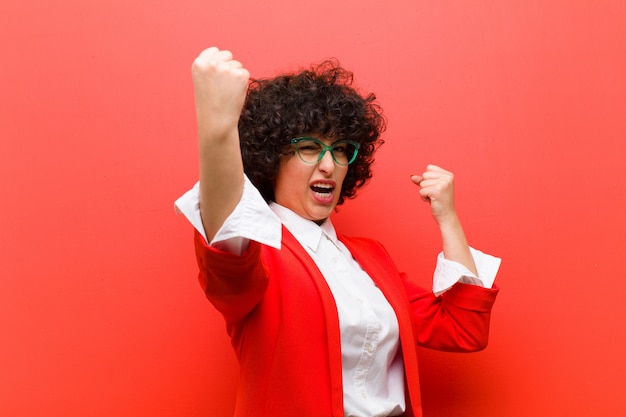 Jonge mooie afro vrouw triomfantelijk schreeuwen