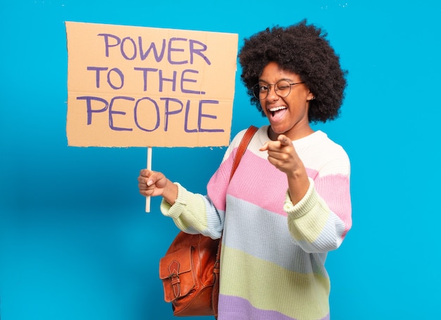 Jonge mooie afrovrouw die met aanplakbiljet protesteert: macht aan de mensen