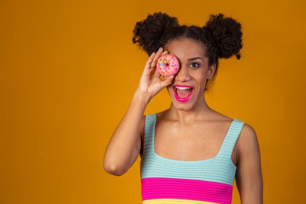 Jonge mooie afrovrouw met een donut