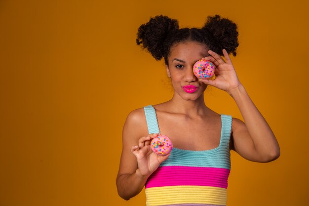 Jonge mooie afrovrouw met een donut