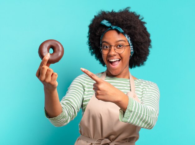 Jonge mooie afrovrouw met een doughnut