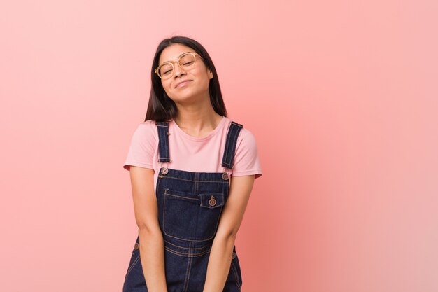 Jonge mooie Arabische vrouw draagt een jeans-dungaree dromen van het bereiken van doelen en doeleinden