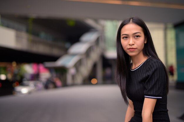 Jonge mooie Aziatische toeristenvrouw bij het wandelgalerij in openlucht