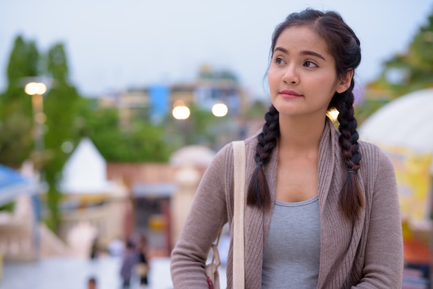 Jonge mooie aziatische toeristenvrouw die nakhon pathom onderzoekt