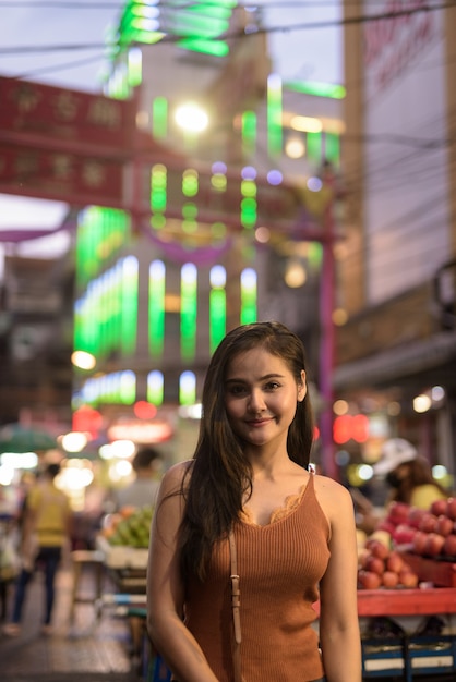 Jonge mooie Aziatische toeristenvrouw in Chinatown bij nacht