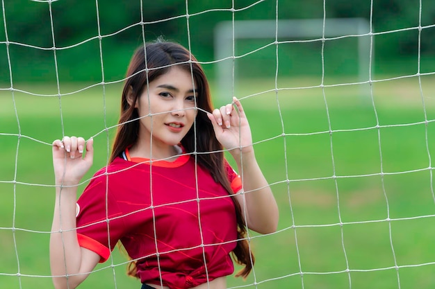 Jonge, mooie aziatische vrouw draagt voetballer cheer sportVrouwelijke fans voetbal juichende game