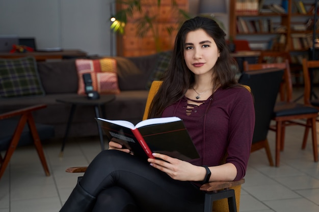 Jonge mooie Aziatische vrouw leesboek in een café