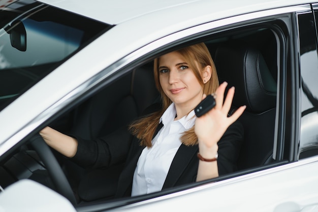 Jonge mooie bedrijfsvrouwenzitting in haar auto