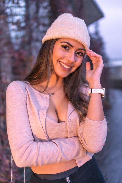 Foto jonge mooie blanke brunette die in de winter door de stad loopt en een roze wollen trui draagt