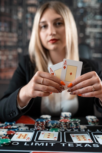 Jonge mooie blanke vrouw die twee azen toont voor overwinning in casino in pokerspel