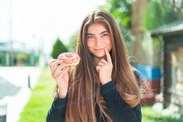 Jonge mooie blanke vrouw met een donut.