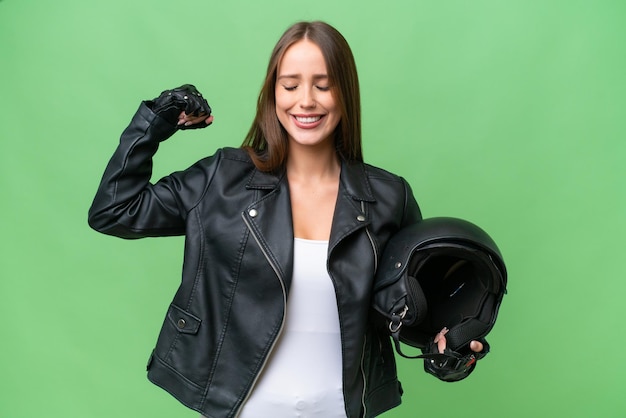 Jonge mooie blanke vrouw met een motorhelm over geïsoleerde achtergrond die een sterk gebaar doet