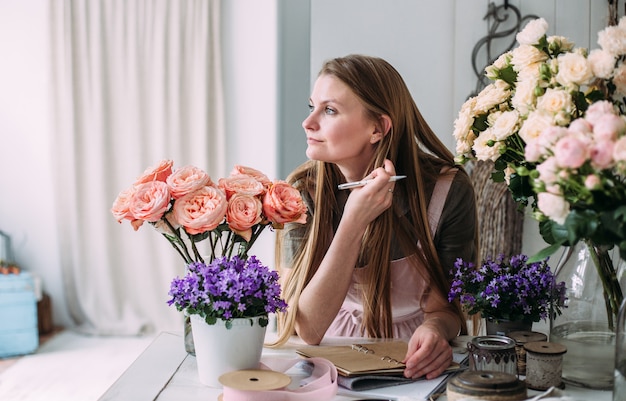 Jonge mooie bloemist in een bloemenwinkel