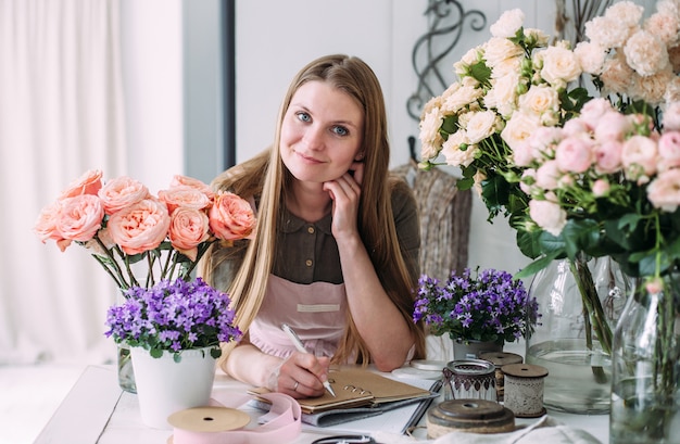 Jonge mooie bloemist in een bloemenwinkel