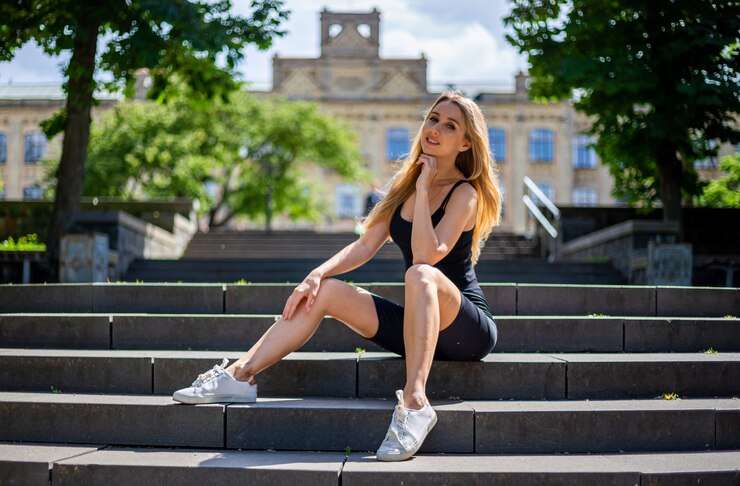 Jonge mooie blonde sportieve vrouw in een zwarte tanktop en in zwarte tight