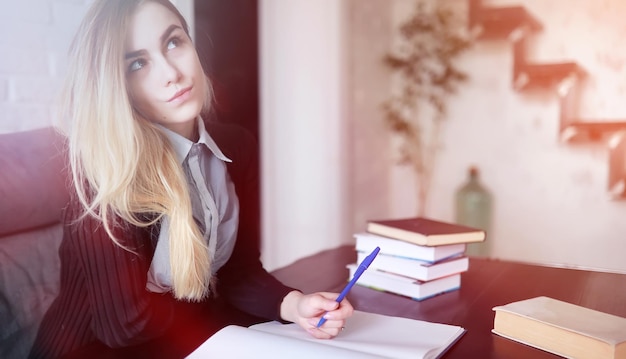 Jonge mooie blonde studente voor de les