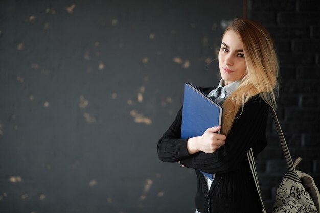 Jonge mooie blonde studente vóór de les