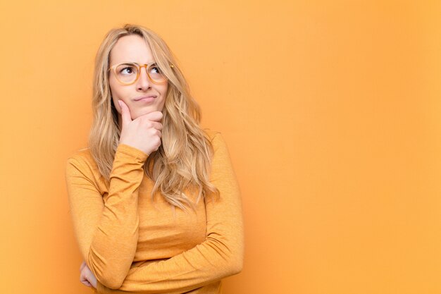 Jonge mooie blonde vrouw denken