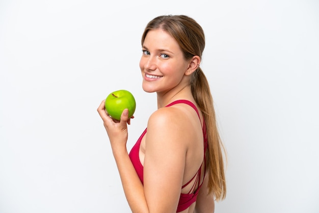 Jonge mooie blonde vrouw geïsoleerd op een witte achtergrond die een appel eet