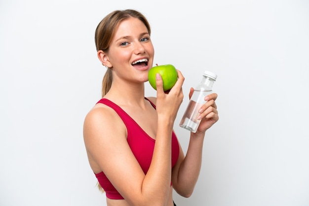 Jonge mooie blonde vrouw geïsoleerd op een witte achtergrond met een appel en met een fles water