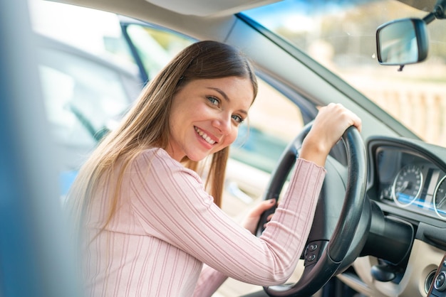 Jonge mooie blonde vrouw in een auto