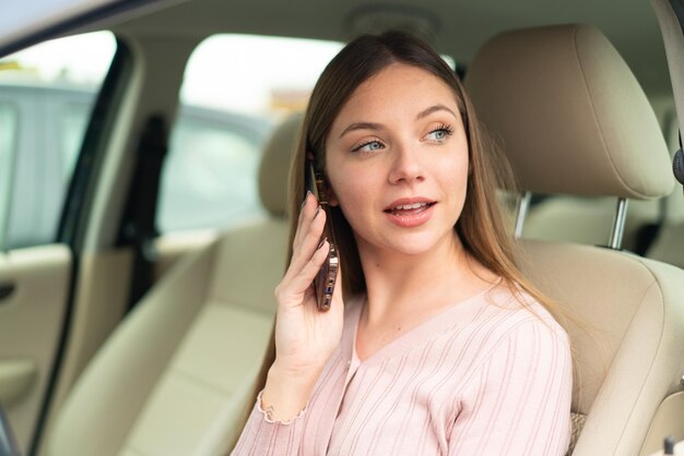 Jonge mooie blonde vrouw in een auto