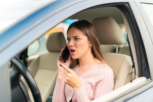 Jonge mooie blonde vrouw in een auto