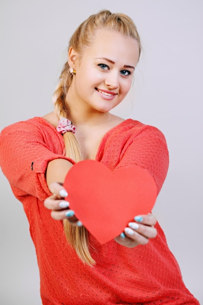 Jonge mooie blonde vrouw met een hart