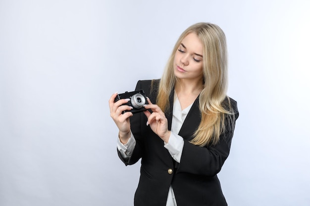 Jonge mooie blonde vrouw met retro camera op witte achtergrond
