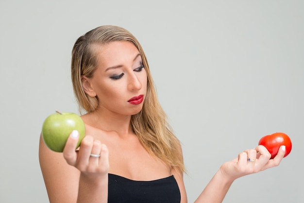 jonge mooie blonde vrouw tegen witte muur