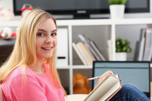 Jonge mooie blonde vrouw thuis werken