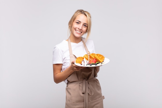 Jonge mooie blonde vrouwenbakker. wafel concept