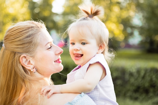Jonge mooie blondemoeder met haar babymeisje die samen lachen