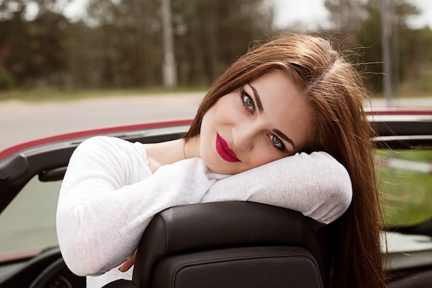 Foto jonge mooie brunette meisje in cabrio