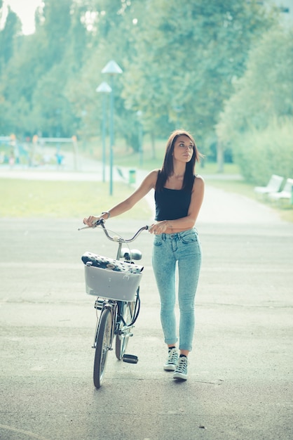 jonge mooie brunette steil haar vrouw met behulp van de fiets