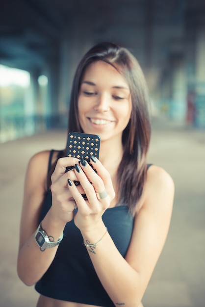 jonge mooie brunette steil haar vrouw met behulp van de smartphone