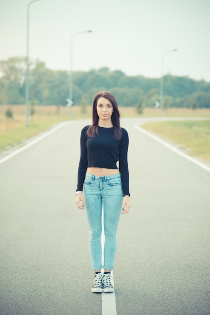 jonge mooie brunette steil haar vrouw op de weg