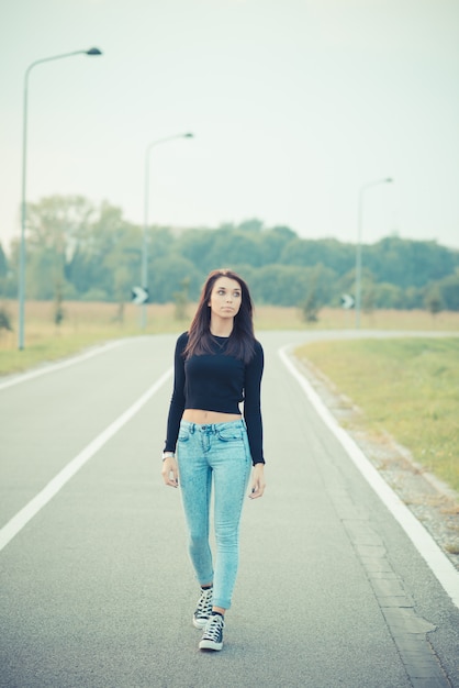 jonge mooie brunette steil haar vrouw op de weg