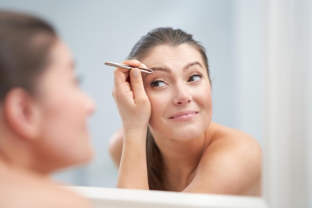 Jonge mooie brunette vrouw in de badkamer Foto van hoge kwaliteit