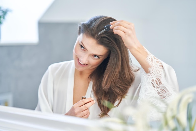 Jonge mooie brunette vrouw in de badkamer Foto van hoge kwaliteit