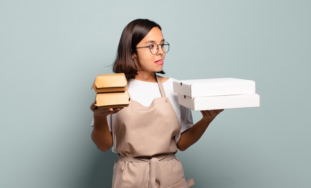 Jonge mooie chef-kokvrouw. snel voedselconcept