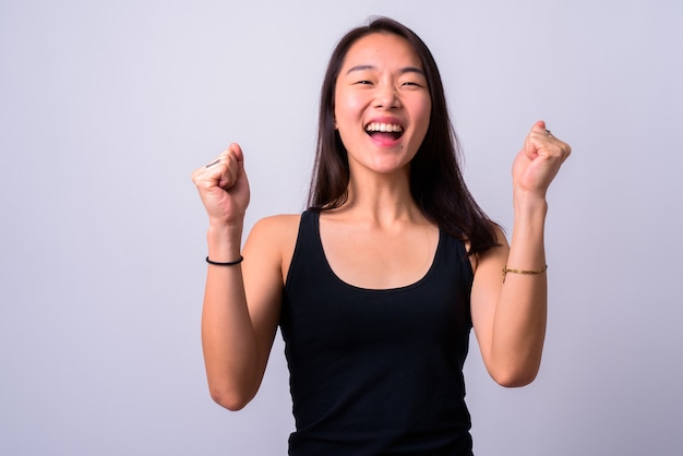 jonge mooie Chinese vrouw tegen witte muur