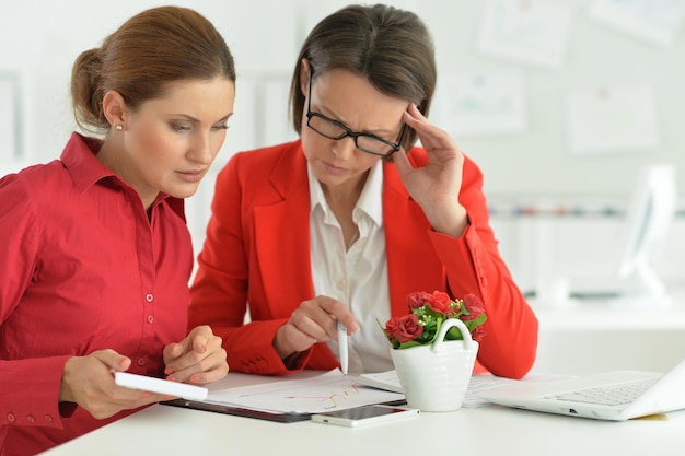 Jonge, mooie en emotionele zakenvrouwen die in een modern kantoor werken