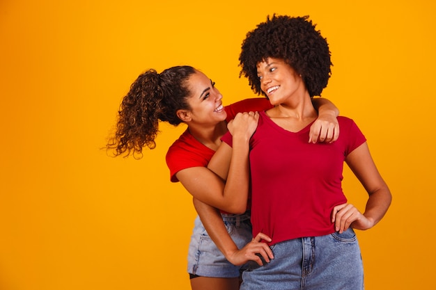 Jonge mooie en gelukkige afro vrouwelijke vrienden die naar de camera glimlachen.