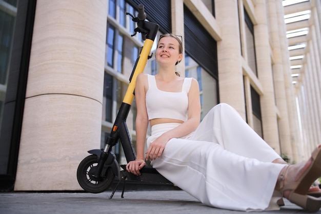 Jonge mooie gelukkige vrouw meisje tiener rijdt electro scooter Electric eco sharing transport