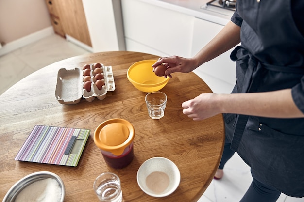 Jonge mooie gemengd ras vrouw bereidt marshmallow bij lichte, moderne keuken thuis